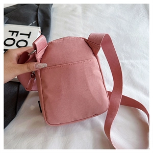 Close-up of pink casual shoulder bag with adjustable strap and rear pocket detail