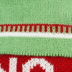 Gros plan d'une chaussette de Noël en tricot rouge et vert avec motif jacquard JOY