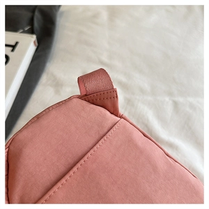 Macro shot of pink fabric texture and precise white stitching on minimalist sports bag