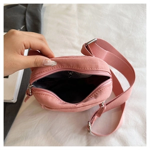 Detail of pink fabric crossbody bag showing grey lining and wide adjustable shoulder strap