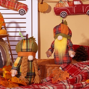 Detail of harvest gnomes with pumpkin hats and maple leaf decor on warm background