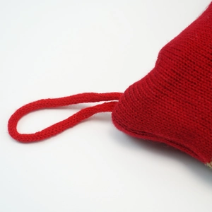 Détail macro d'une chaussette de Noël en tricot rouge montrant la texture et l'attache