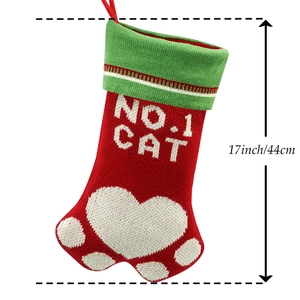 Détail d'une chaussette de Noël en forme de patte de chat rouge et verte avec des cœurs