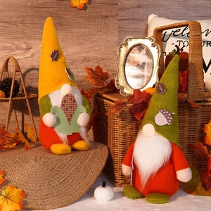 Close-up of autumn gnome plush ornaments with corn and acorn details on burlap