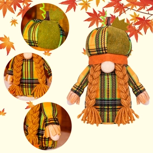 Detailed view of harvest gnome with pumpkin hat and yellow braided hair for autumn decor