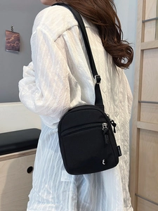 Minimalist black nylon crossbody bag for sports with adjustable strap shown on model