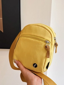 Minimalist bright yellow nylon crossbody sports bag with adjustable strap and zip pocket