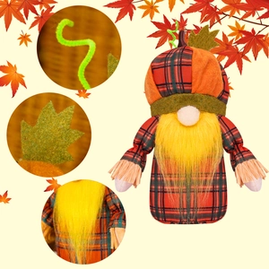 Detailed view of harvest gnome with pumpkin hat and textured red and green plaid fabric