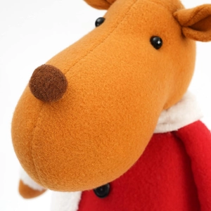 Close-up of plush reindeer doll with red velvet coat and faux fur collar detail