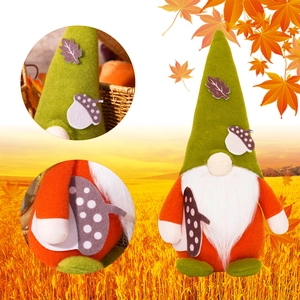 Close-up of autumn gnome doll with orange body, green hat and felt maple leaf details