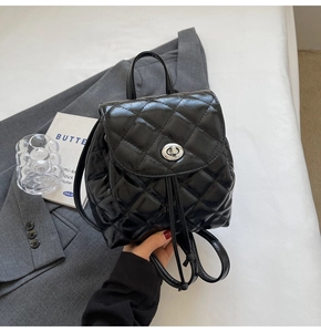 Detailed view of black quilted mini backpack featuring silver twist lock and drawstring