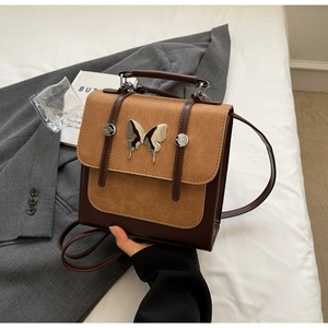 Detail of vintage brown contrast backpack with silver butterfly and rivet accents