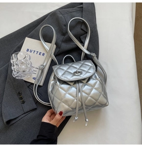 Close-up of silver quilted leather mini backpack with metal twist lock and drawstring