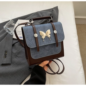 Detail of color-block backpack with metal butterfly clasp and denim leather patchwork