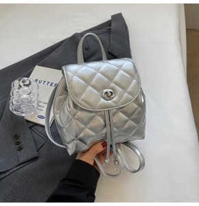 Silver metallic quilted mini backpack with turn-lock clasp and drawstring detail