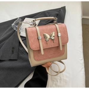 Close-up of pink and beige two-tone backpack with silver butterfly clasp detail