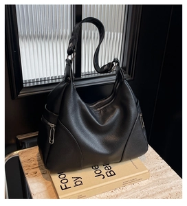 Detail of black lychee grain leather hobo bag with silver metal rings and double zipper