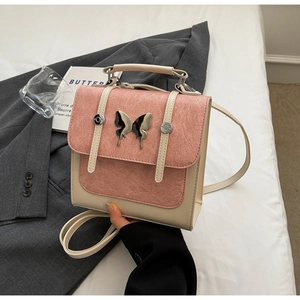 Close-up of contrast color mini backpack featuring a silver butterfly metal clasp