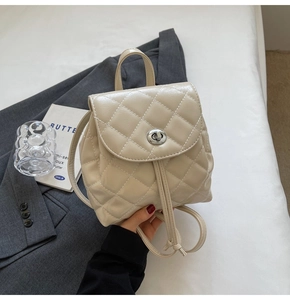 Close-up of quilted cream leather mini backpack with silver twist lock and drawstring