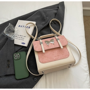 Detail of contrast color backpack with silver butterfly buckle on white bedding scene
