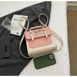 Detail of color-block mini backpack with silver butterfly accent and smooth finish