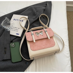 Detail view of contrast color backpack with silver butterfly clasp and pink suede flap