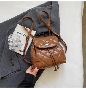 Close-up of caramel brown quilted PU backpack with metal twist lock and drawstring detail