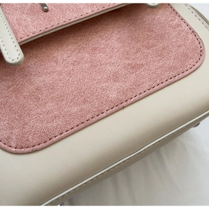 Detail of color-block backpack showing pink suede texture and silver metal hardware