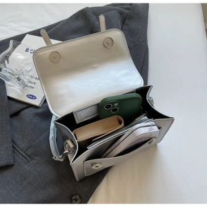 Vue intérieure du sac à bandoulière argenté montrant les poches et le rangement