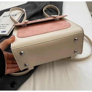 Close-up of base metal studs on a cream and pink patchwork backpack with stitching detail