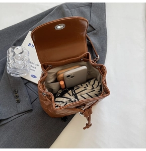 Close-up of brown quilted bucket backpack showing large capacity for phone and wallet