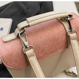 Close-up of pink textured fabric and beige leather stitching with silver metal hardware