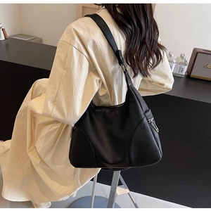 Close-up of black lychee grain faux leather shoulder bag with side zipper pocket detail
