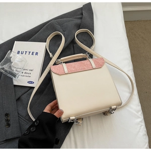 Detail of contrast-color leather backpack showing beige body and pink suede flap detail