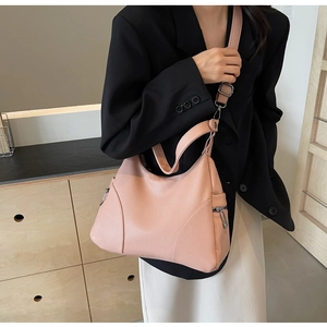 Detail view of pink dumpling bag showing lychee pattern texture and side zipper