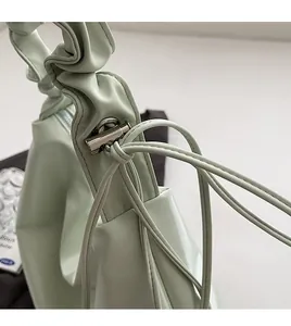 Detail der mintgrünen PU-Leder Umhängetasche mit Kordelzug und silbernem Verschluss