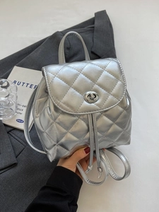 Silver quilted backpack with metallic finish featuring twist lock and drawstring closure