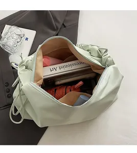 Geräumiges Innenfach der mintgrünen Rafftasche mit Regenschirm und Büchern befüllt