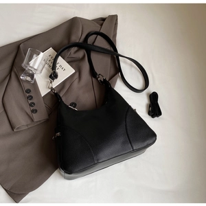 Close-up of black lychee grain leather hobo bag with adjustable strap and silver hardware