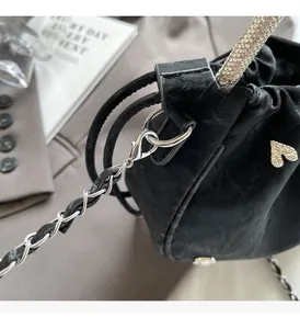 Close-up of luxury black bucket bag with silver chain strap and sparkling diamond heart detail