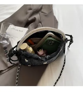 Detail of black velvet bucket bag showing spacious interior with phone and cosmetics