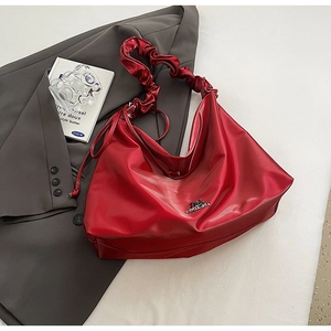 Detail der roten gerafften Ledertasche mit seitlichem Kordelzug und Logo-Verzierung