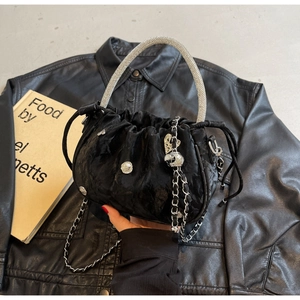 Close-up of black pleated cloud bag with rhinestone handle and silver heart charms