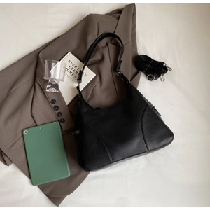 Detail of black lychee texture leather handbag with adjustable detachable shoulder strap