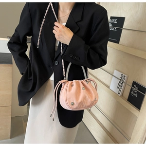 Detail of pink pleated cloud bucket bag with heart charms and rhinestone handle