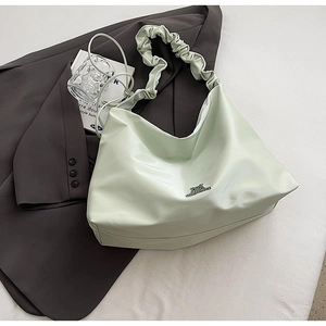 Detail der mintgrünen Hobo-Tasche mit Faltenoptik und glänzender Oberfläche