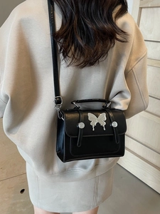 Sac bandoulière en cuir noir minimaliste avec papillon en métal argenté et bandoulière
