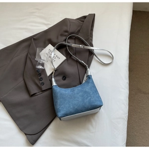 Detail of blue suede half-moon bag with silver leather trim and adjustable strap
