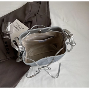 Interior view of silver glitter bucket bag featuring drawstring closure and inner zip pocket