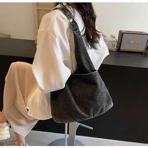 Side view of large grey washed denim hobo bag with wide shoulder strap and vintage texture